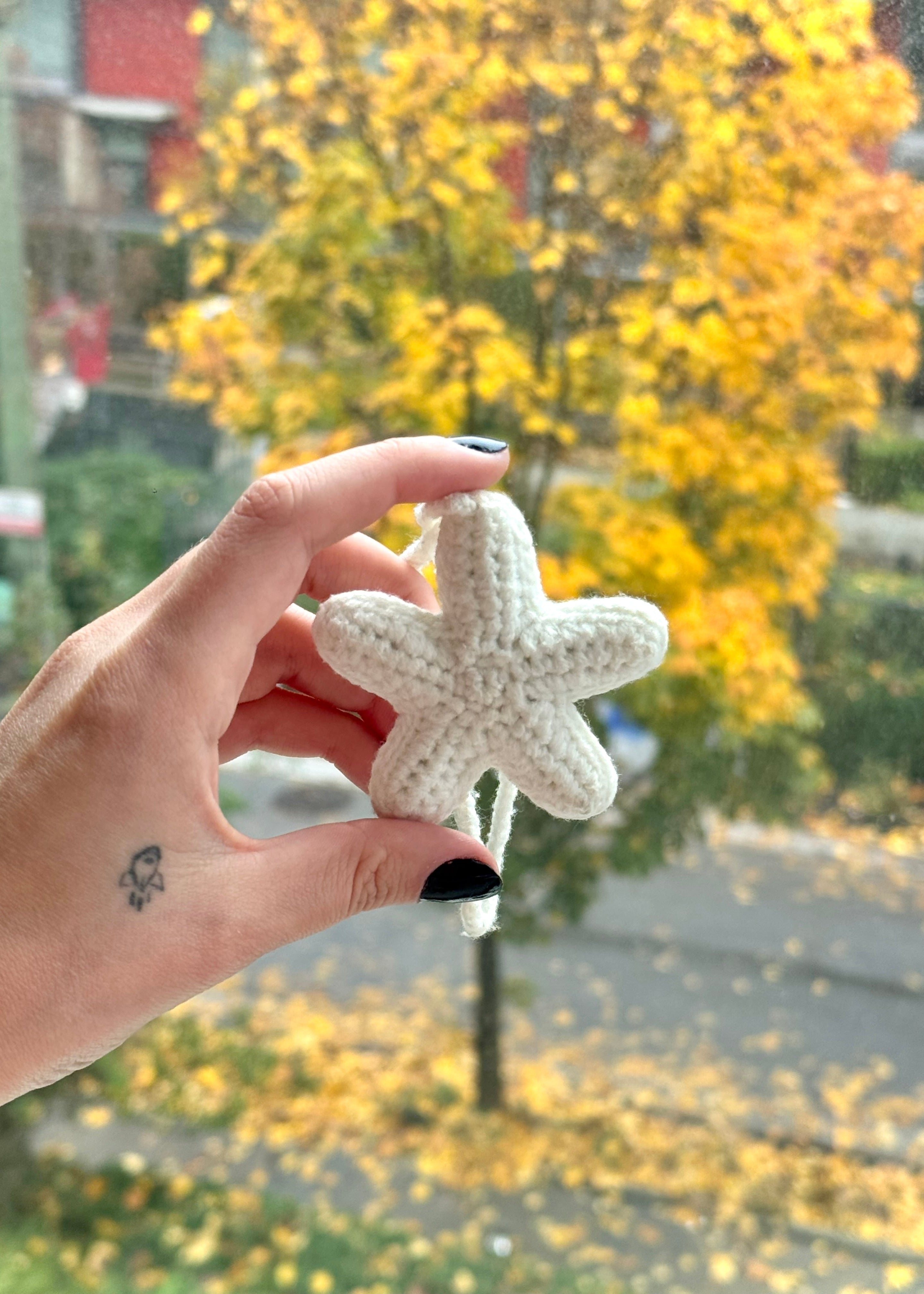 A white crocheted seastar bag charm