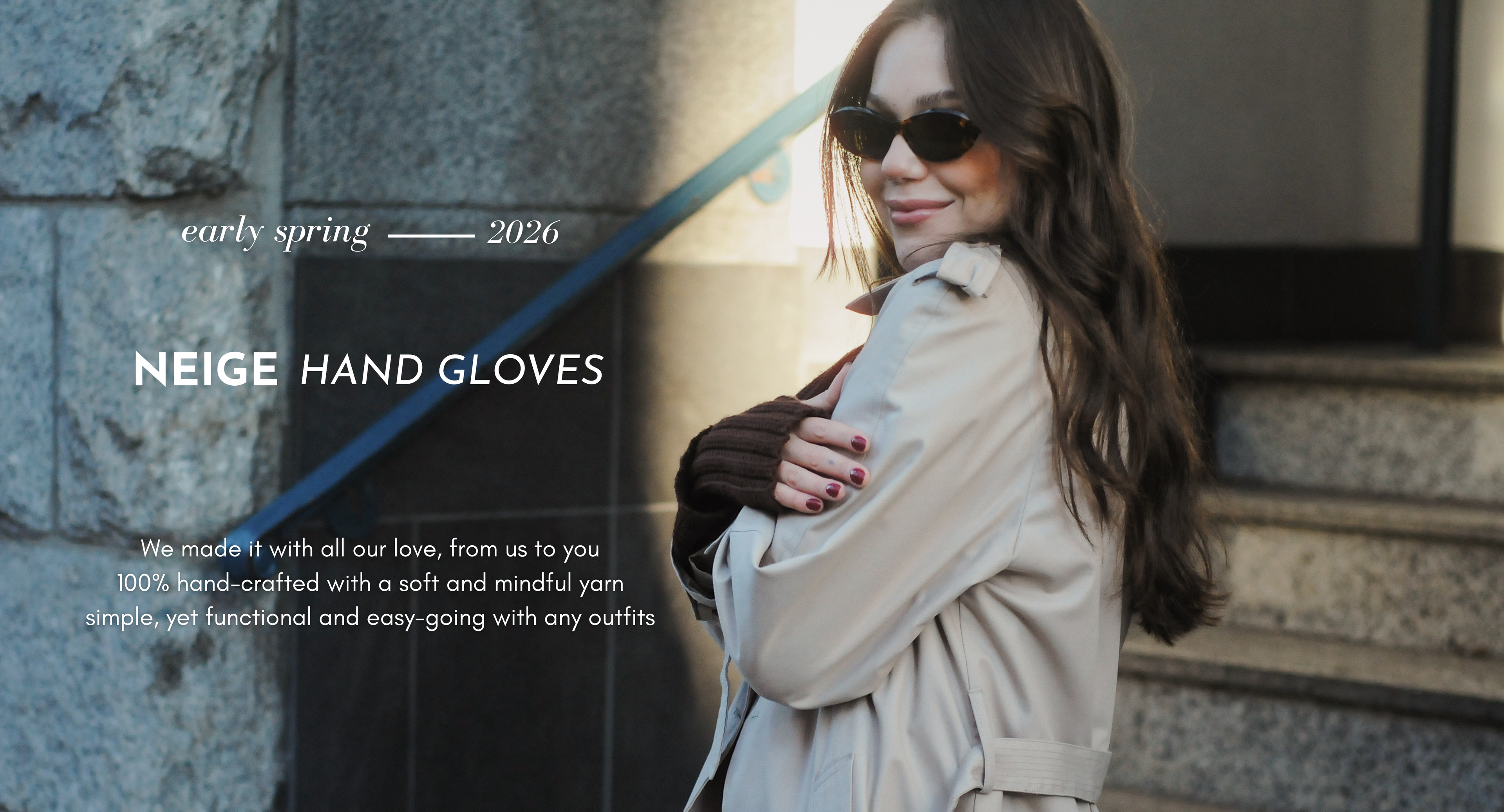 Woman wearing NEIGE hand gloves with a stone wall background